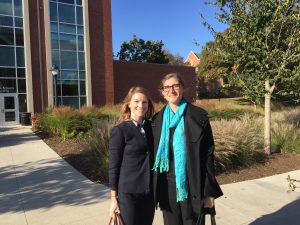 Meg Smith, a 2013 Ed.D cohort, posing for a picture outside of Gentry, the main building for NEAG