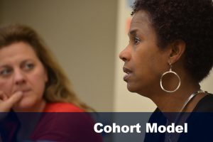 A woman speaks during a 2014 Ed.D. class. [Text reads: Cohort Model. | Links to cohort model information.]